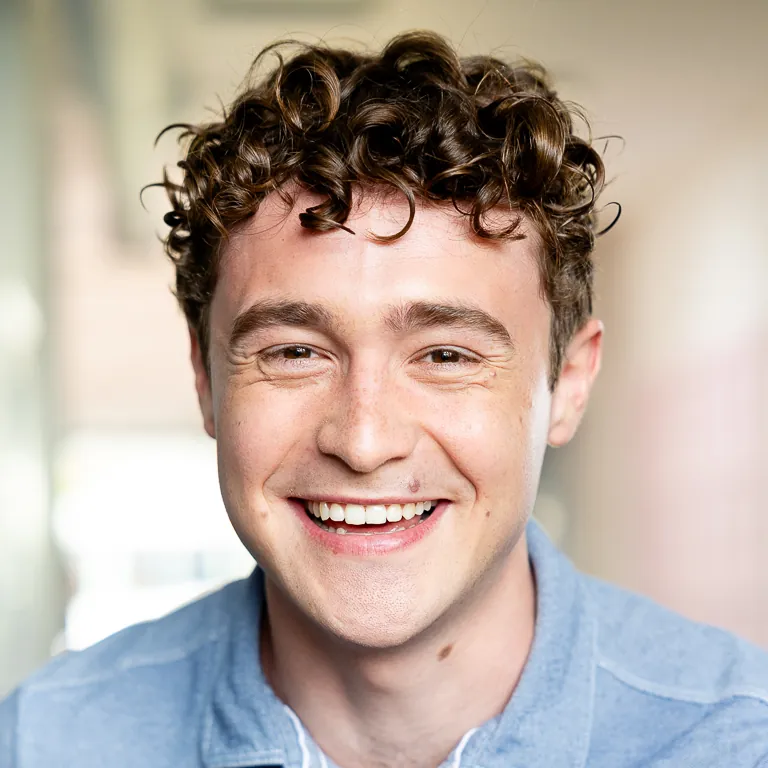 Headshot of Dane Hobrecht laughing in a studio.